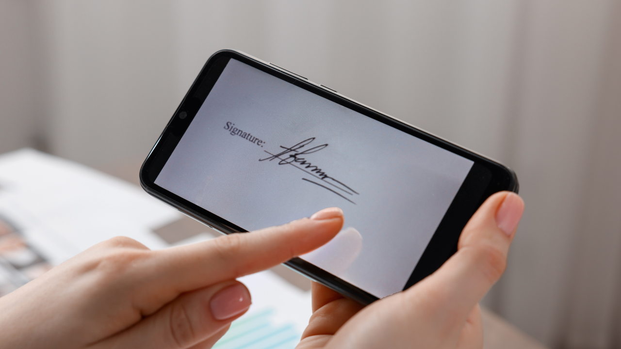 Client drawing a digital signature on a smartphone screen for a Glow Forms consent—secure, time-stamped e-signature.