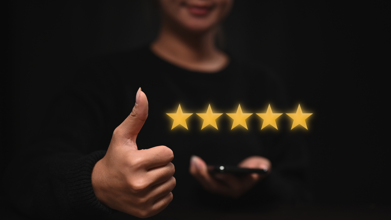 Client giving thumbs-up with glowing five-star rating on phone—proof of VIP service and a great salon experience.