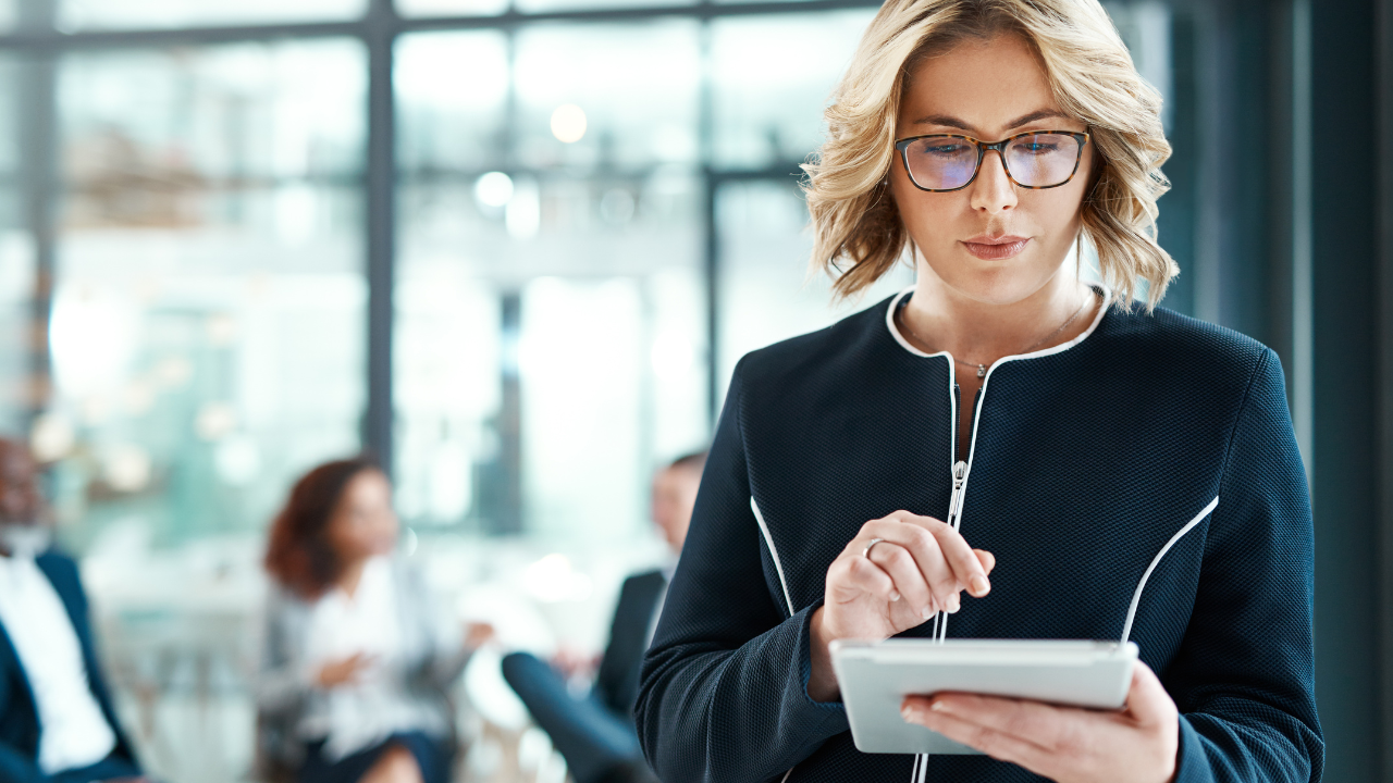 Beauty business owner checks service pricing and policies on a tablet at the salon.