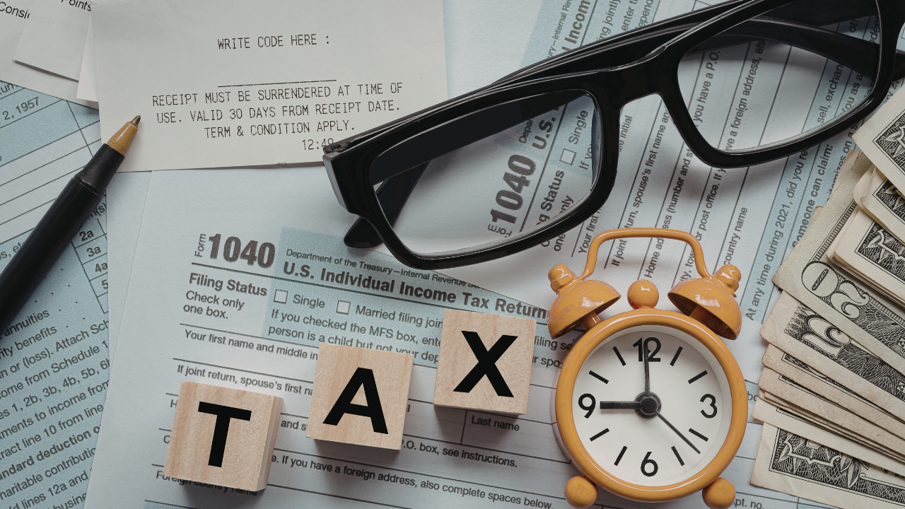 Flat lay of tax documents with a receipt, glasses, a small clock, and money—beauty business finances theme.