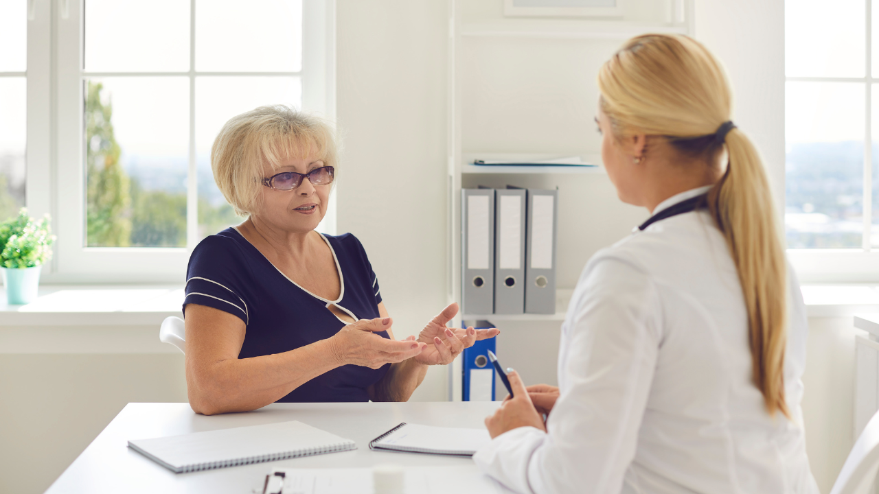 Client explains a reaction while a practitioner listens and takes notes—calm, professional consultation.