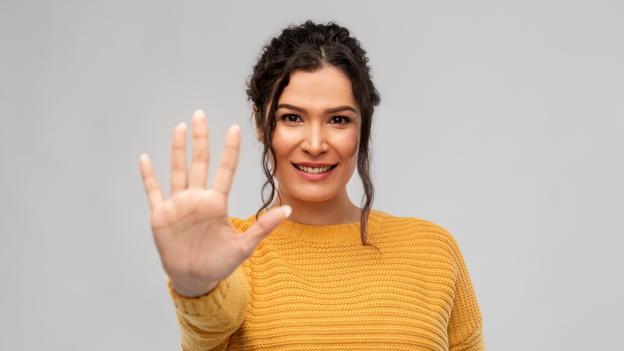 Salon owner checking automations on a phone while a client scans a QR code at the desk