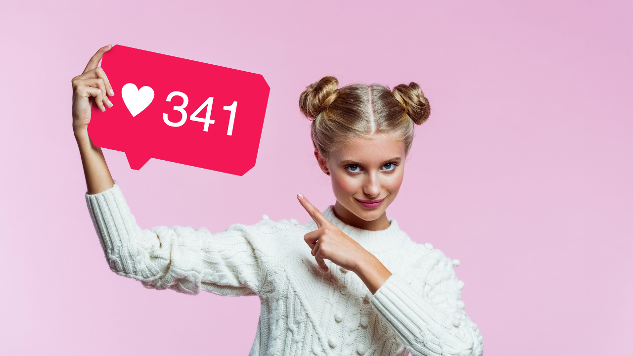 Influencer holding a like-count icon and pointing to it on a pink background.
