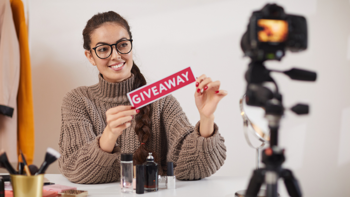 Salon owner records a targeted giveaway video, holding a “GIVEAWAY” sign with beauty products on the table.