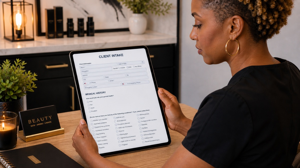 Beauty professional reviewing and updating client intake and consent forms